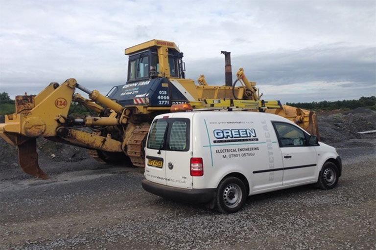 Green Electrical van beside heavy plant at Gibson Bros, Banbridge